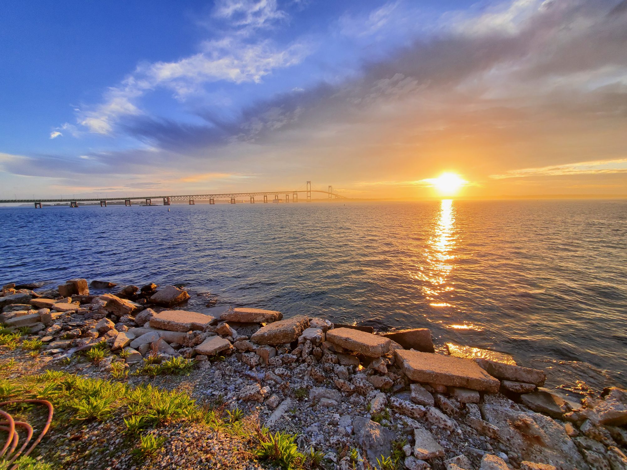 Sun rising beside the Newport Pell Bridge, golden light on Narragansett Bay, Naval Station Newport, Rhode Island